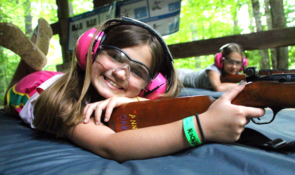 Camp kid posing while shooting a rifle