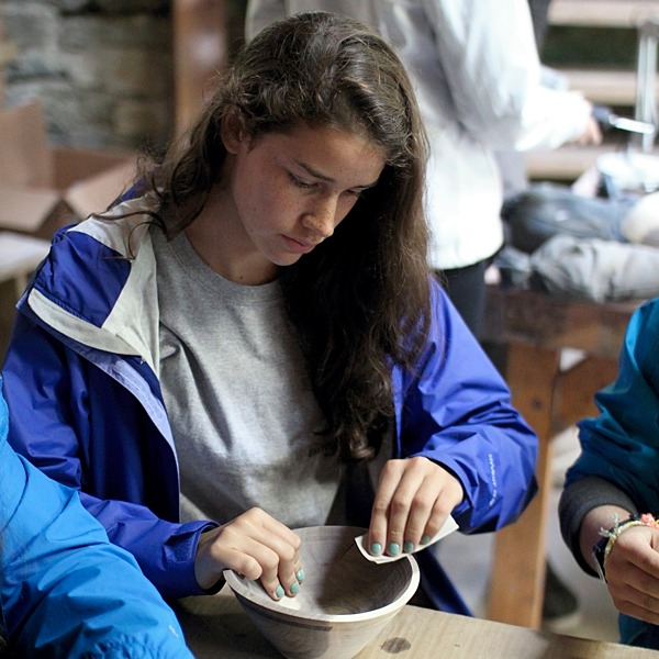 Camper sanding wooden bowl