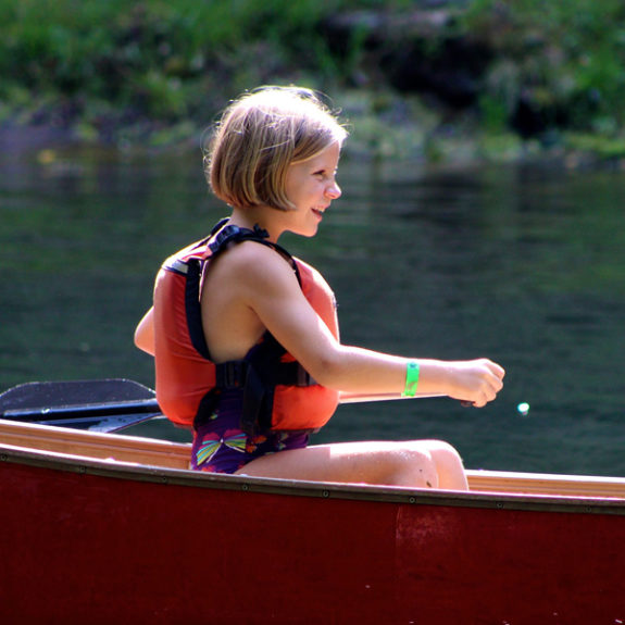 girl learning to paddle canoe