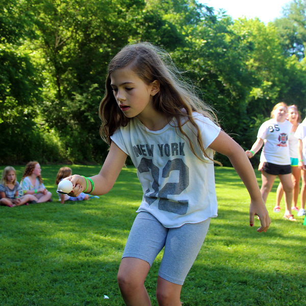 Camper carrying egg on spoon racing