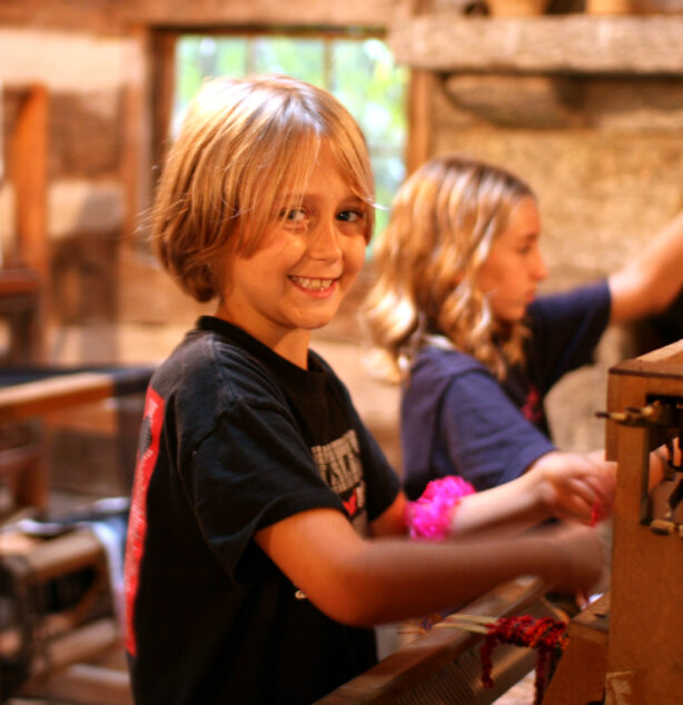 Small girl weaving at camp