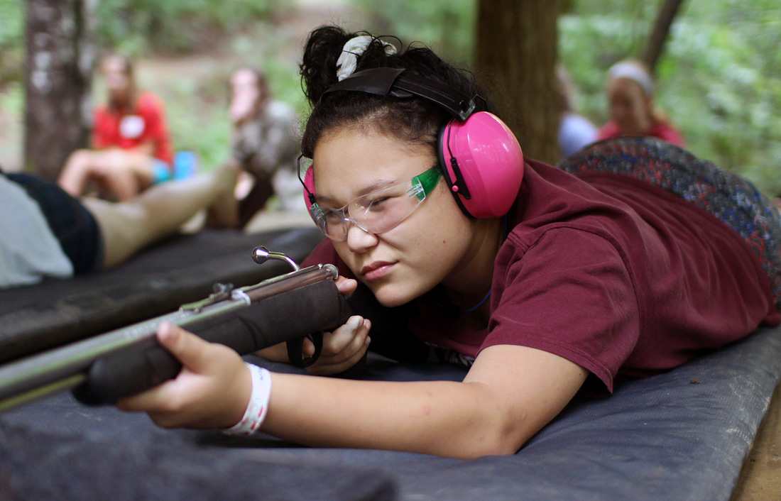 camp girl aiming rifle