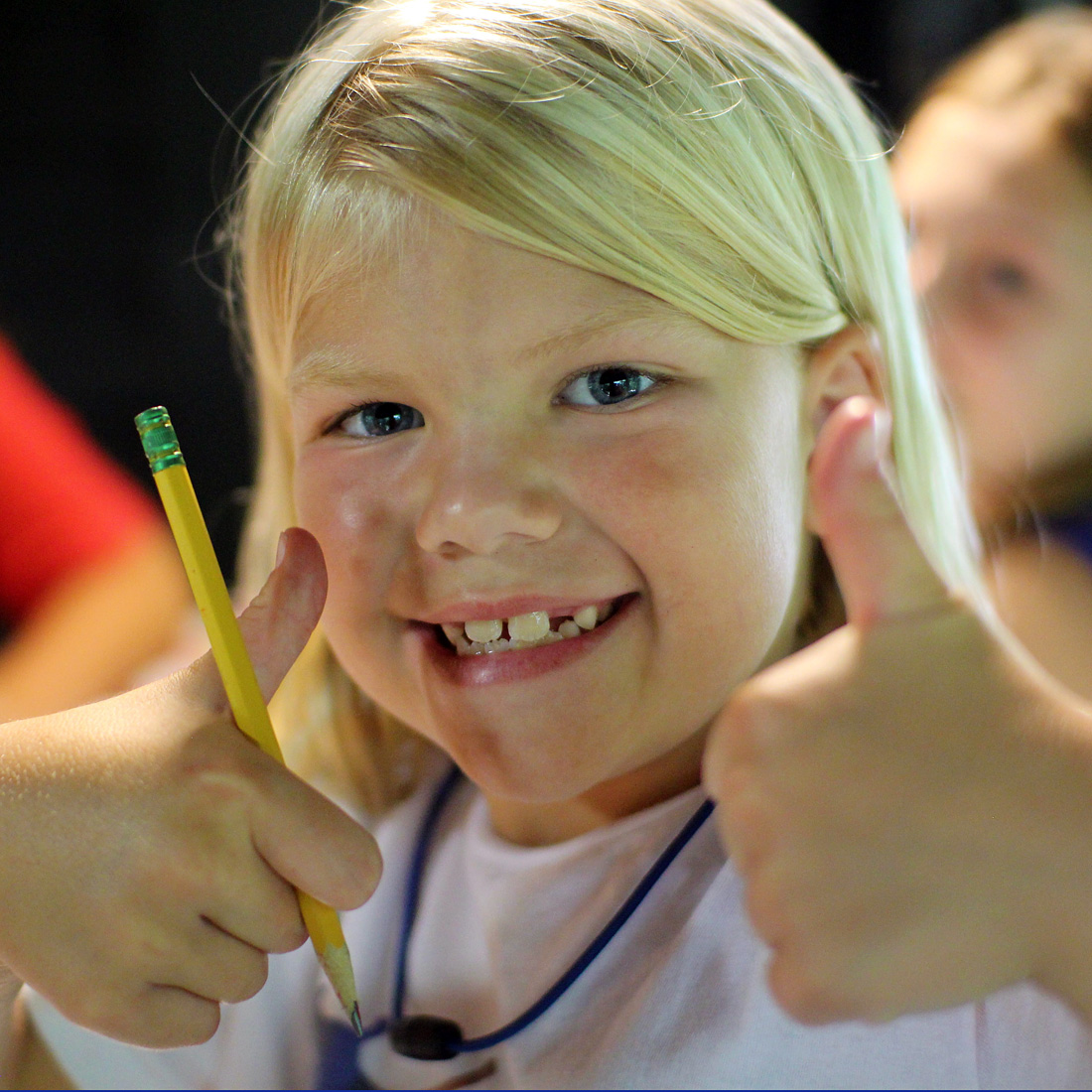 girl smiling two thumbs up