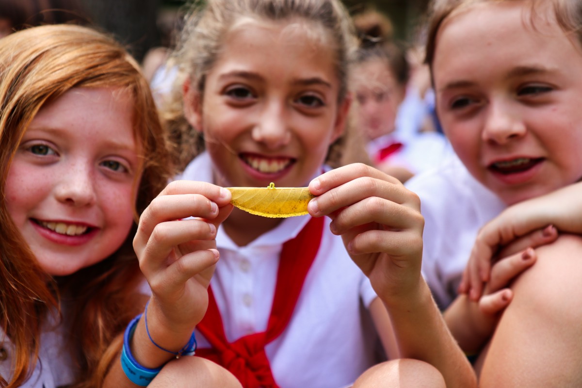 girl hold leaf with inchworm