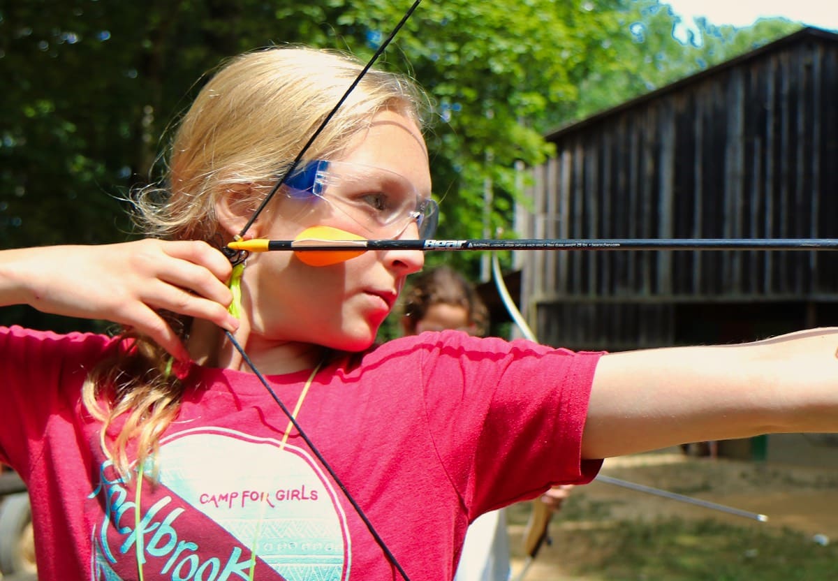 camp girl pulling archery bow