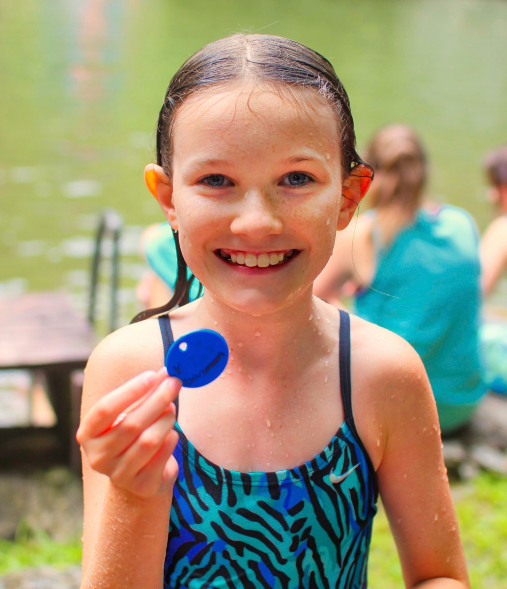 Girl with buddy tag after completing camp swim test 