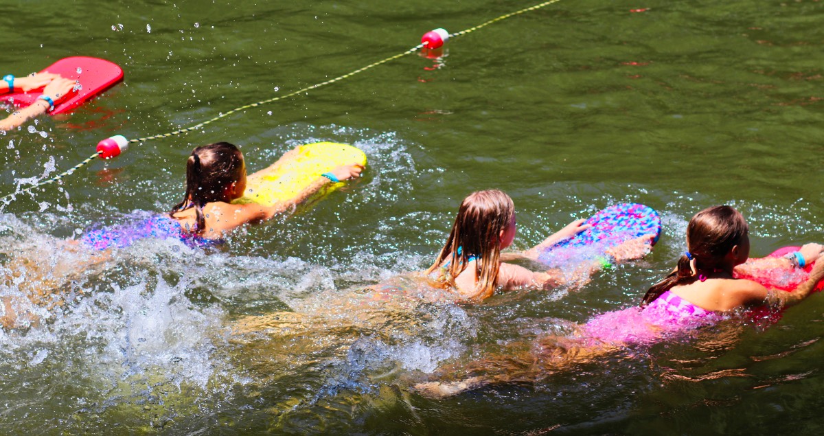 swimming with kickboards together in the lake