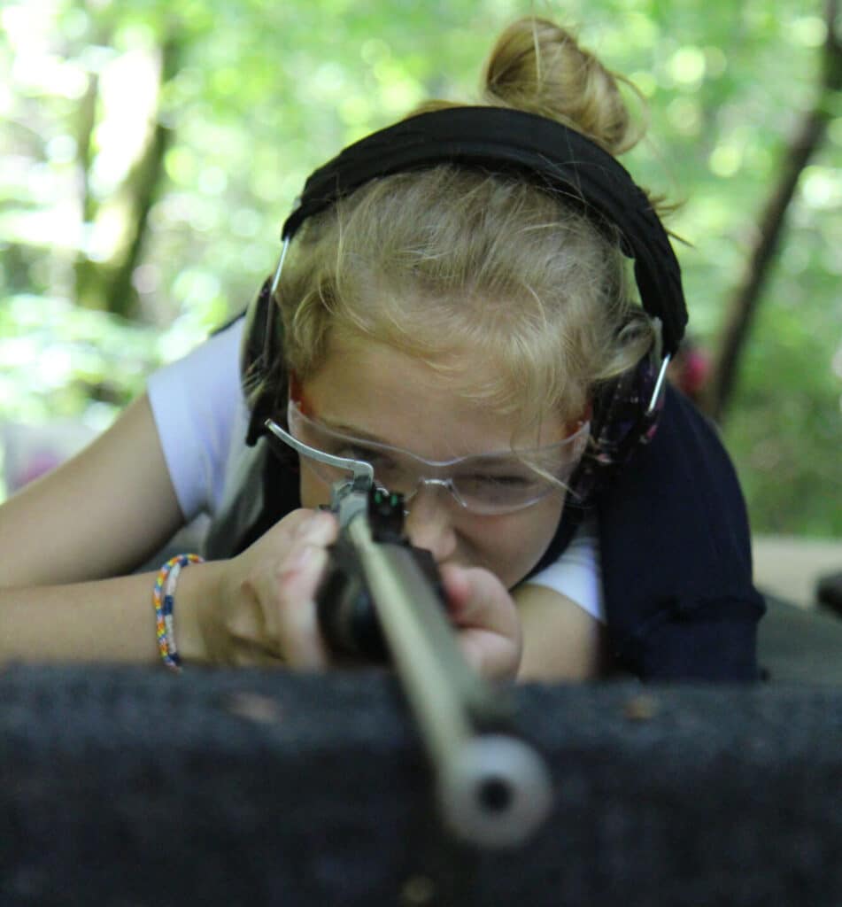 girl aiming rifle at target