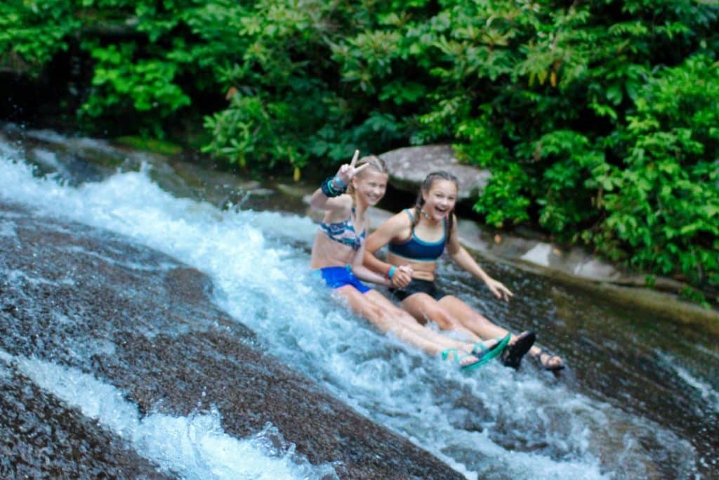 Girls sliding rock peace sign