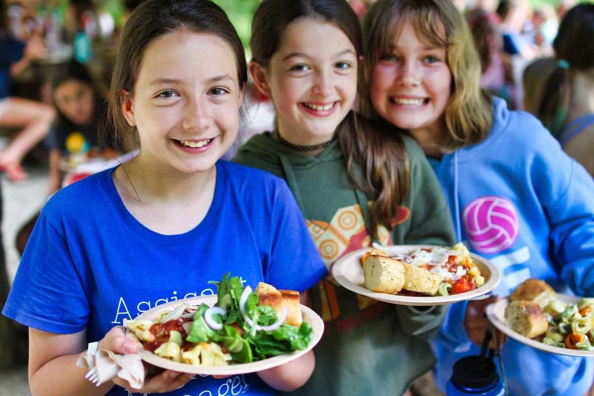 camp kids holding picnic dinner