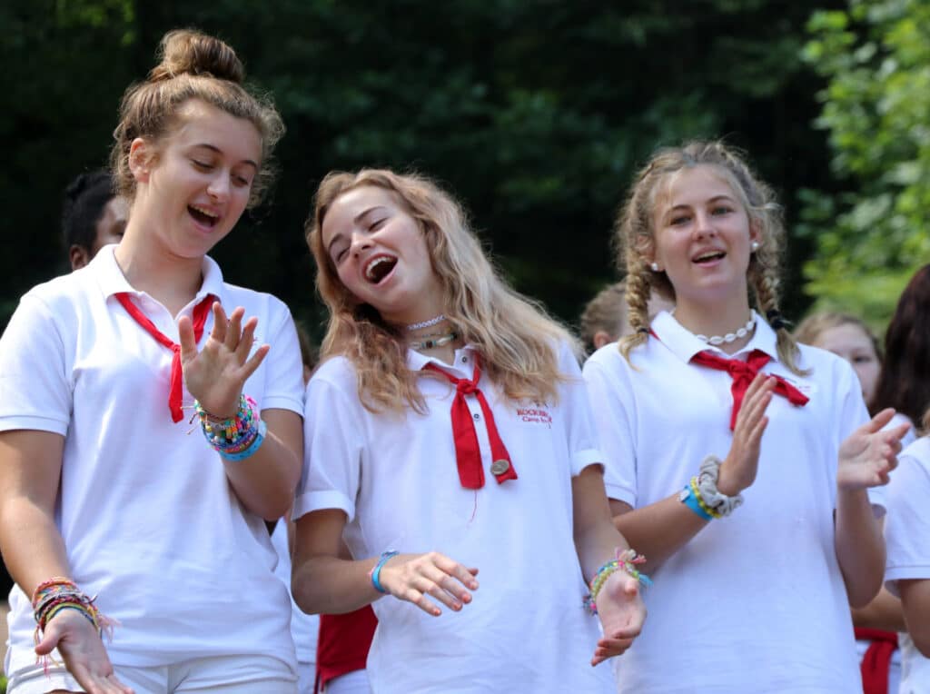 three teen girls in camp uniforms