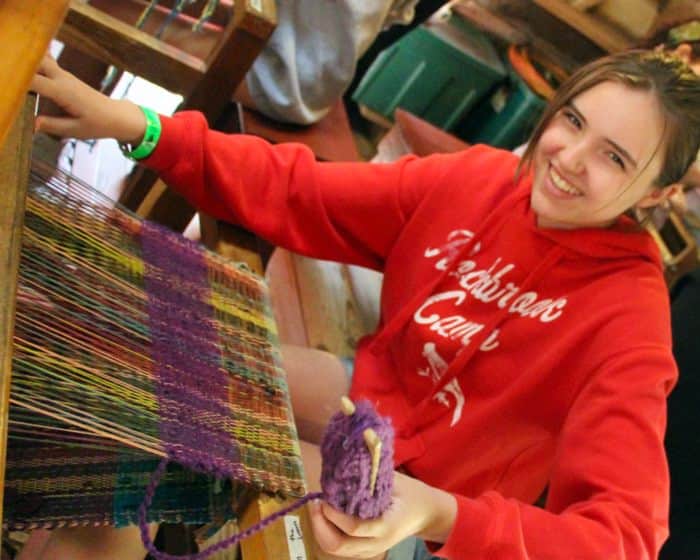girl craft weaving at camp