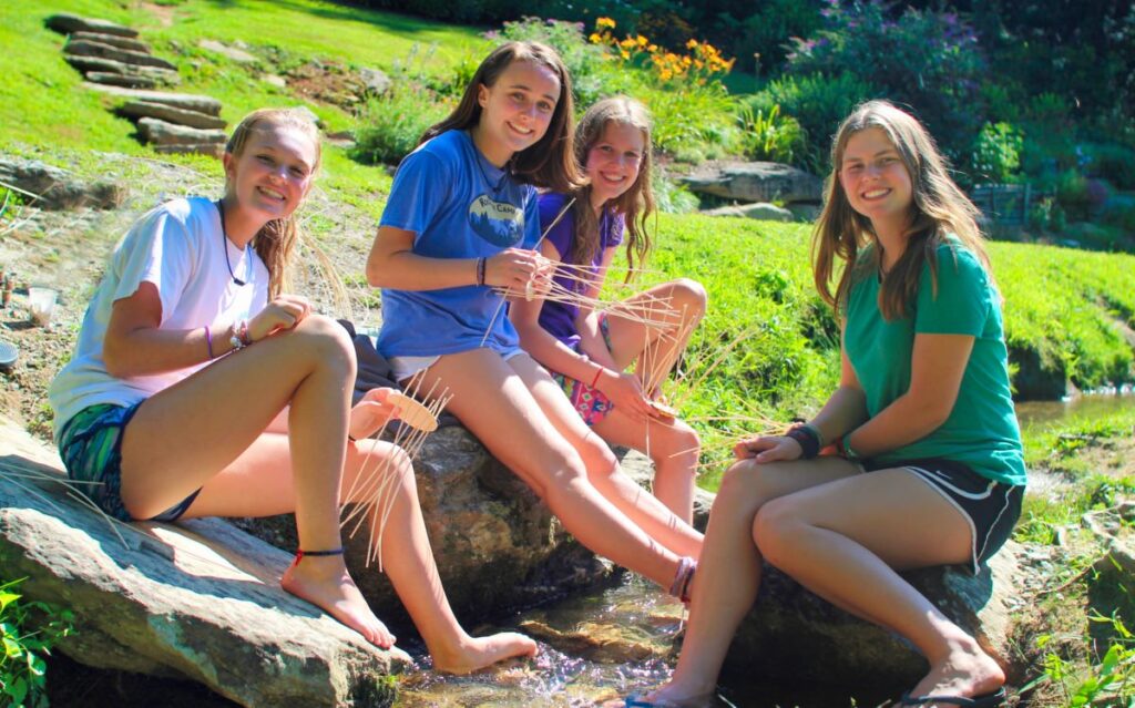 girls' camp teenagers weaving baskets in the creek