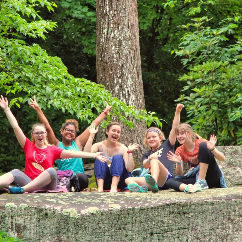 waving group of campers and staff members