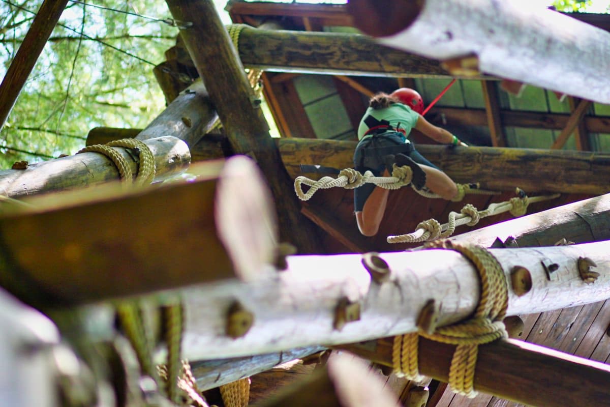 girl climbing rope on challenge element