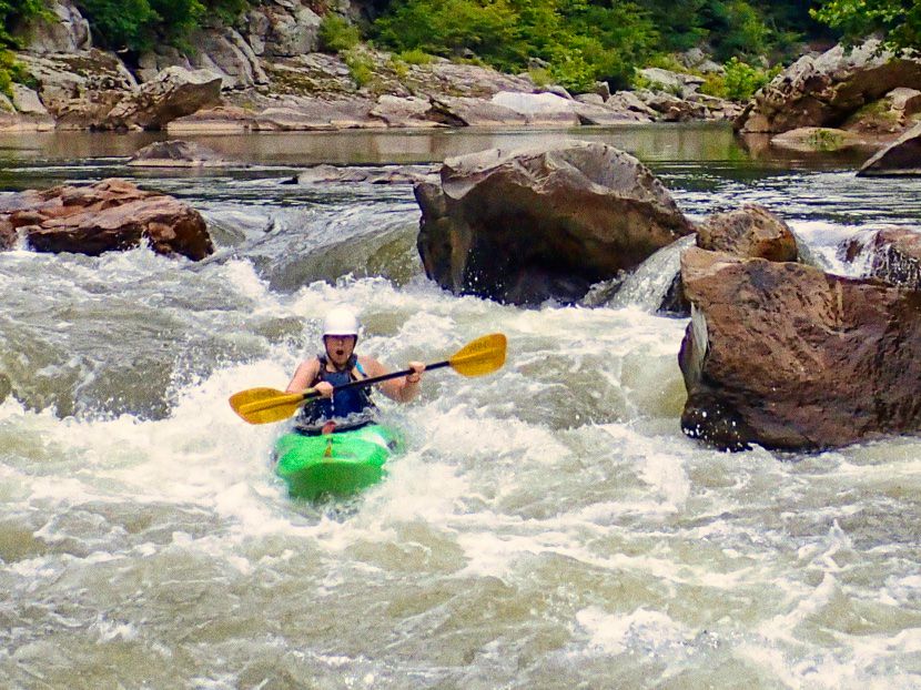 camp girl kayaking big rapid