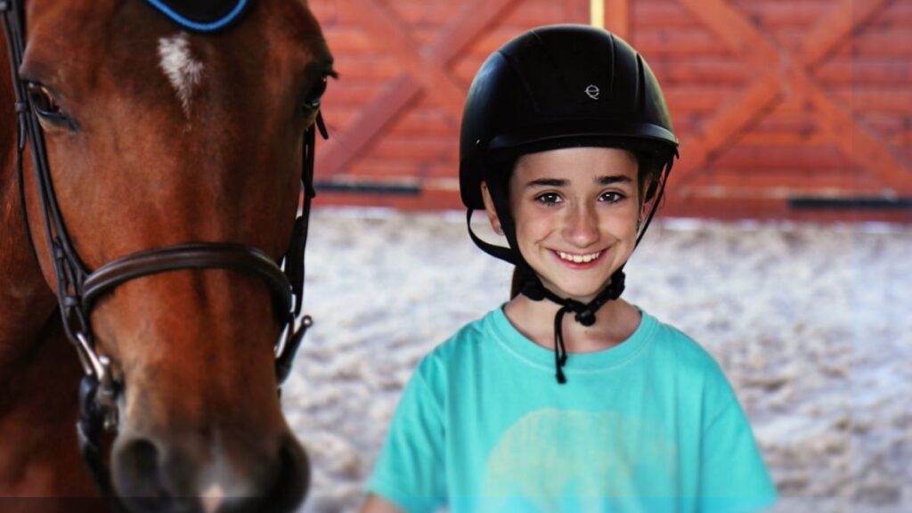 child and horse at summer camp