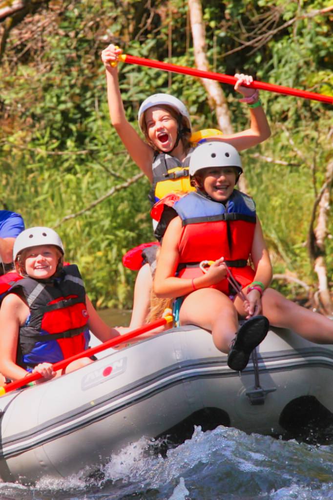 camp kid cheering while rafting