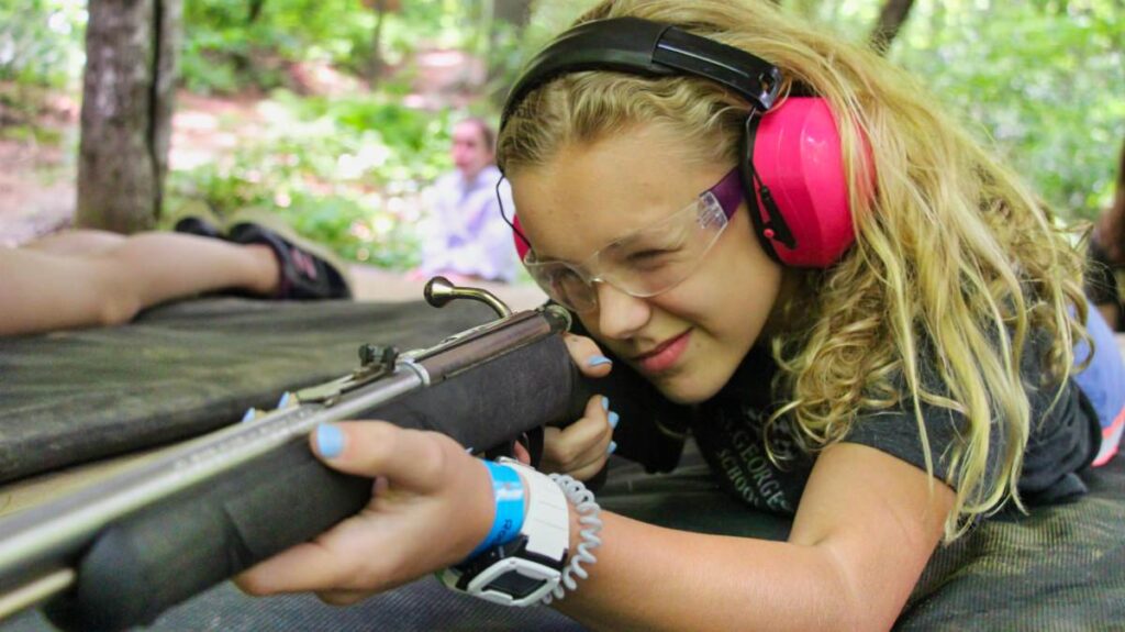 camp girl aiming rifle
