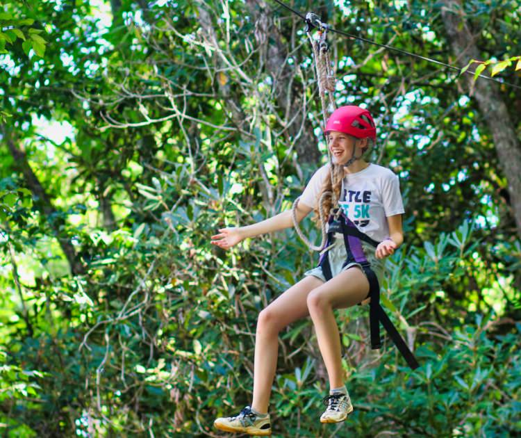 wide-eyed smiling camp zipline girl