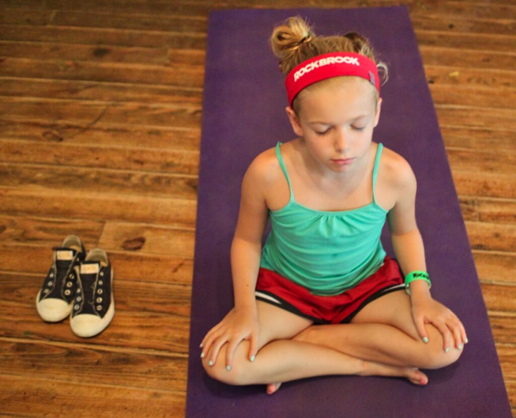 child doing yoga pose at summer camp