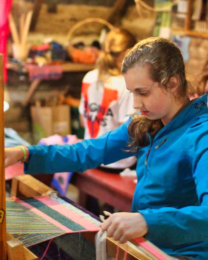 teen girl working floor loom