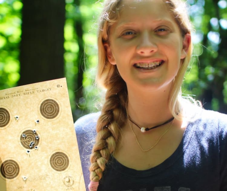 camp girl holding her shooting target