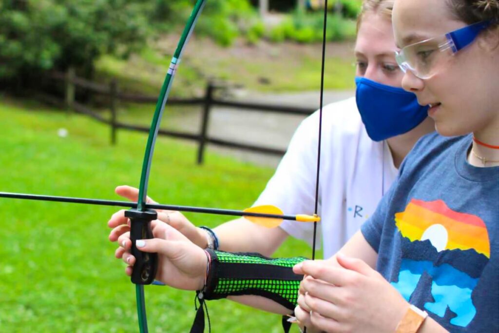 teaching archery at summer camp