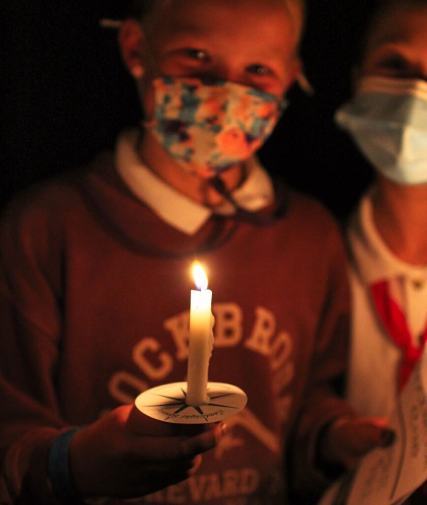 girl holding candle for closing campfire ceremony