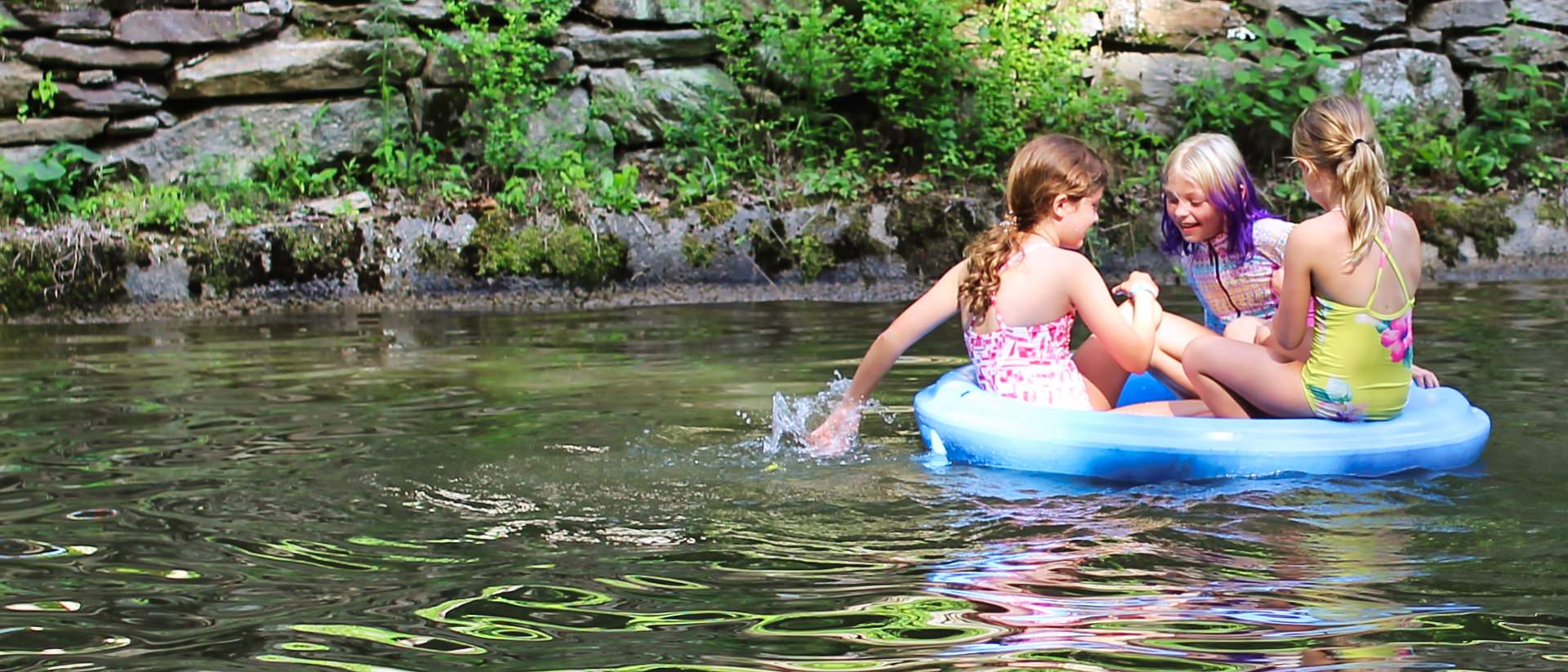 girls floating in camp lake