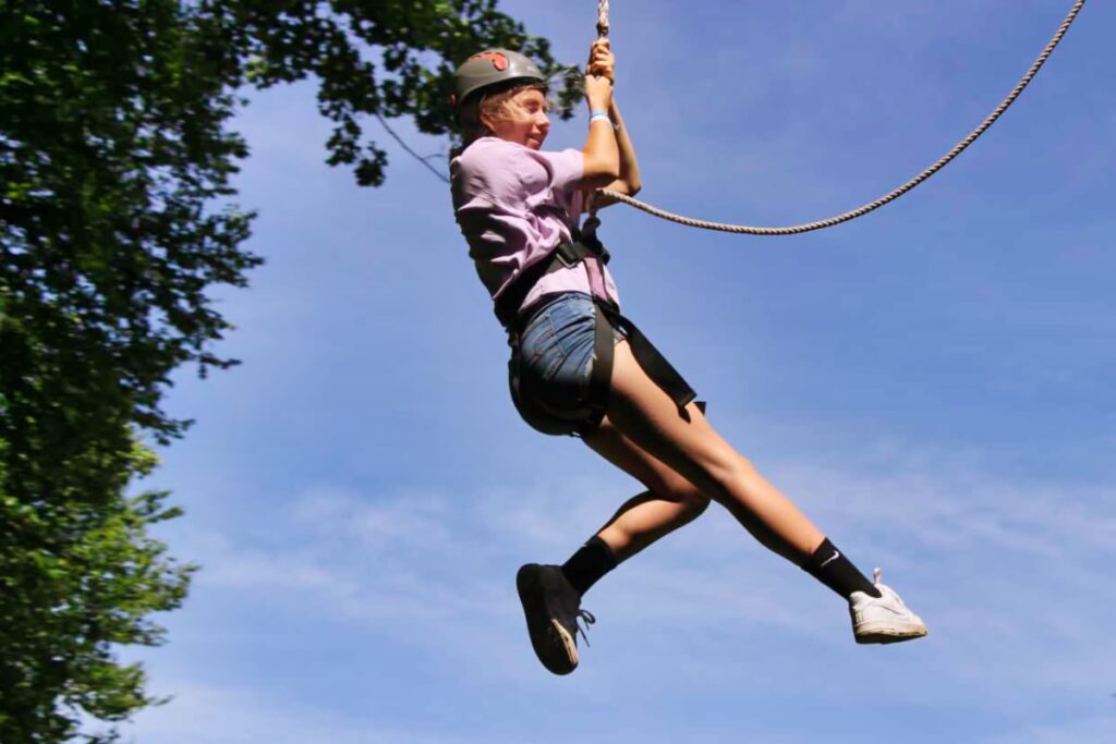 girl flying high on camp zip line