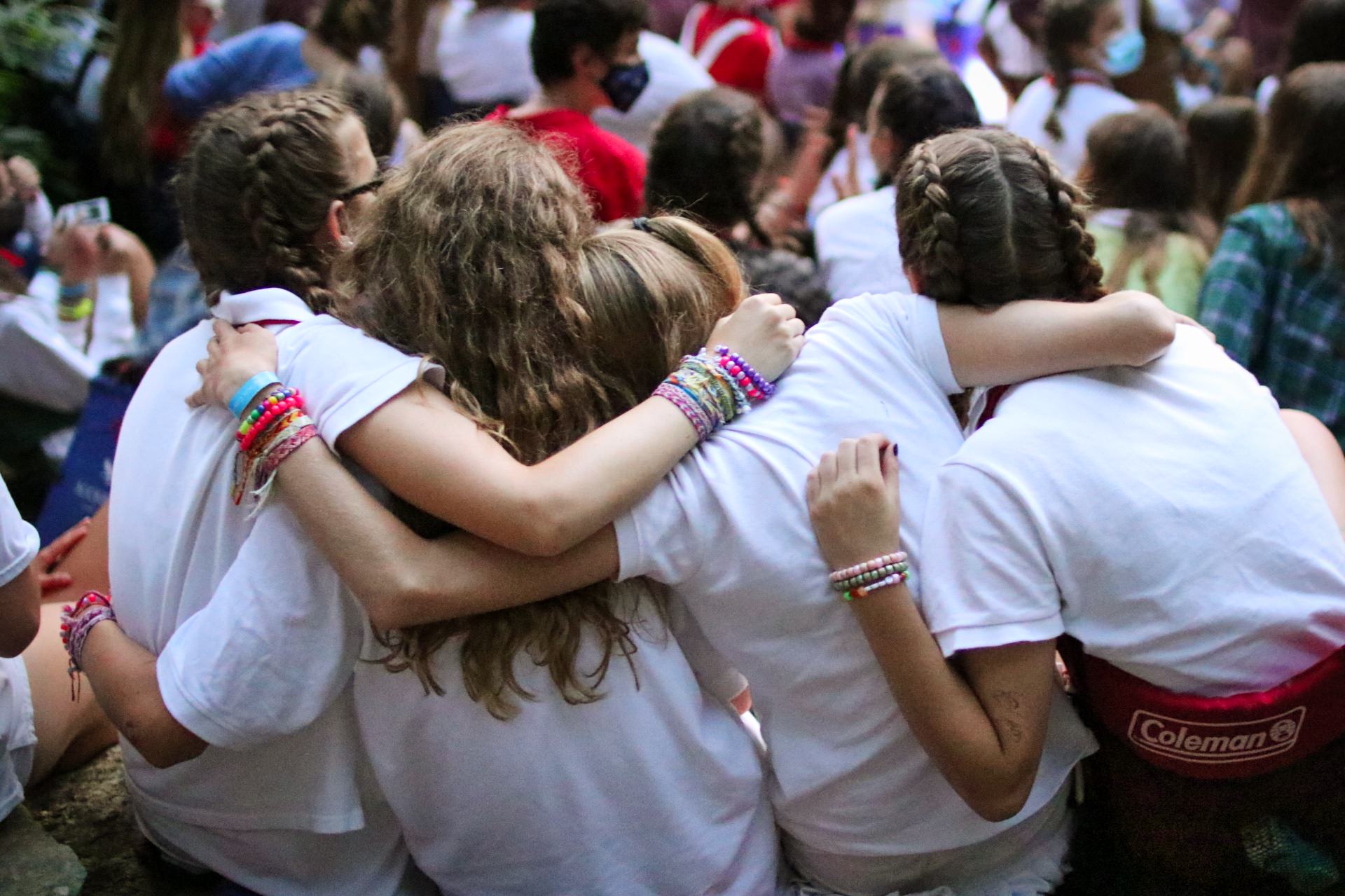 Camp girls hugging at campfire