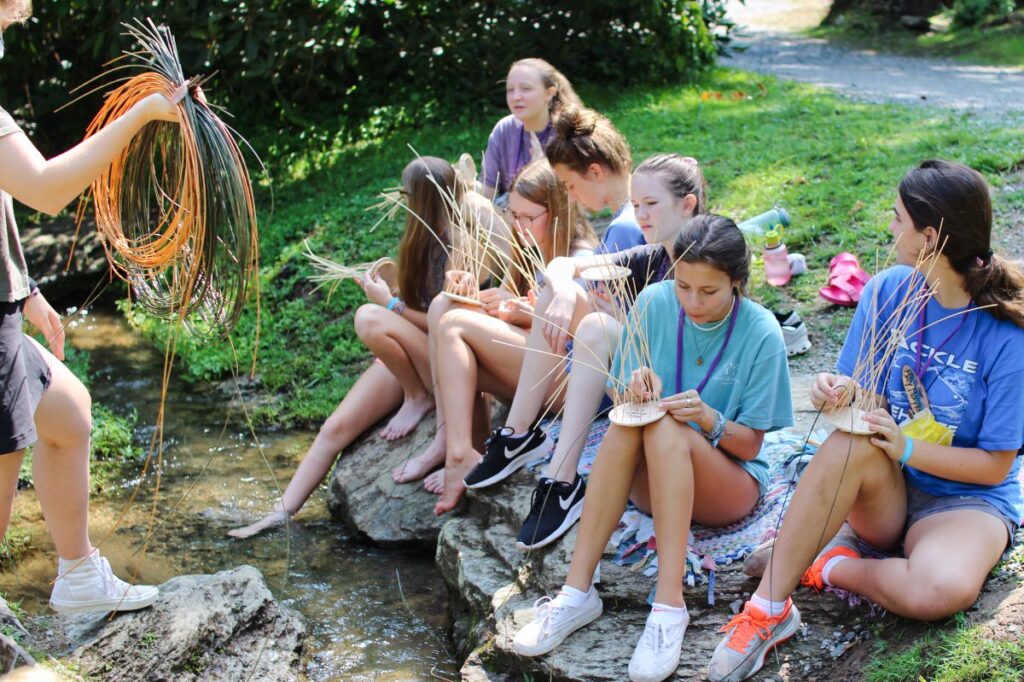 girls basket weaving near creek