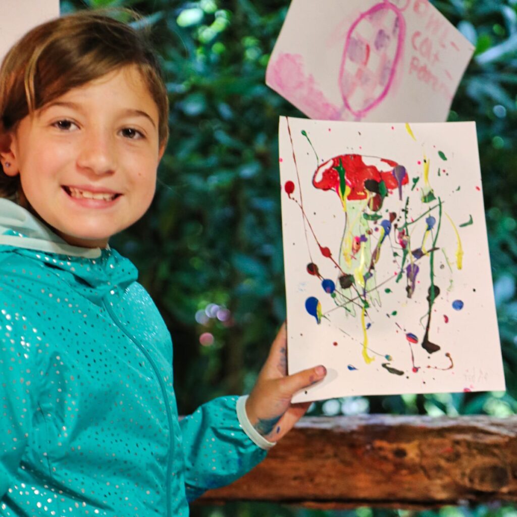 young girl displaying her painting