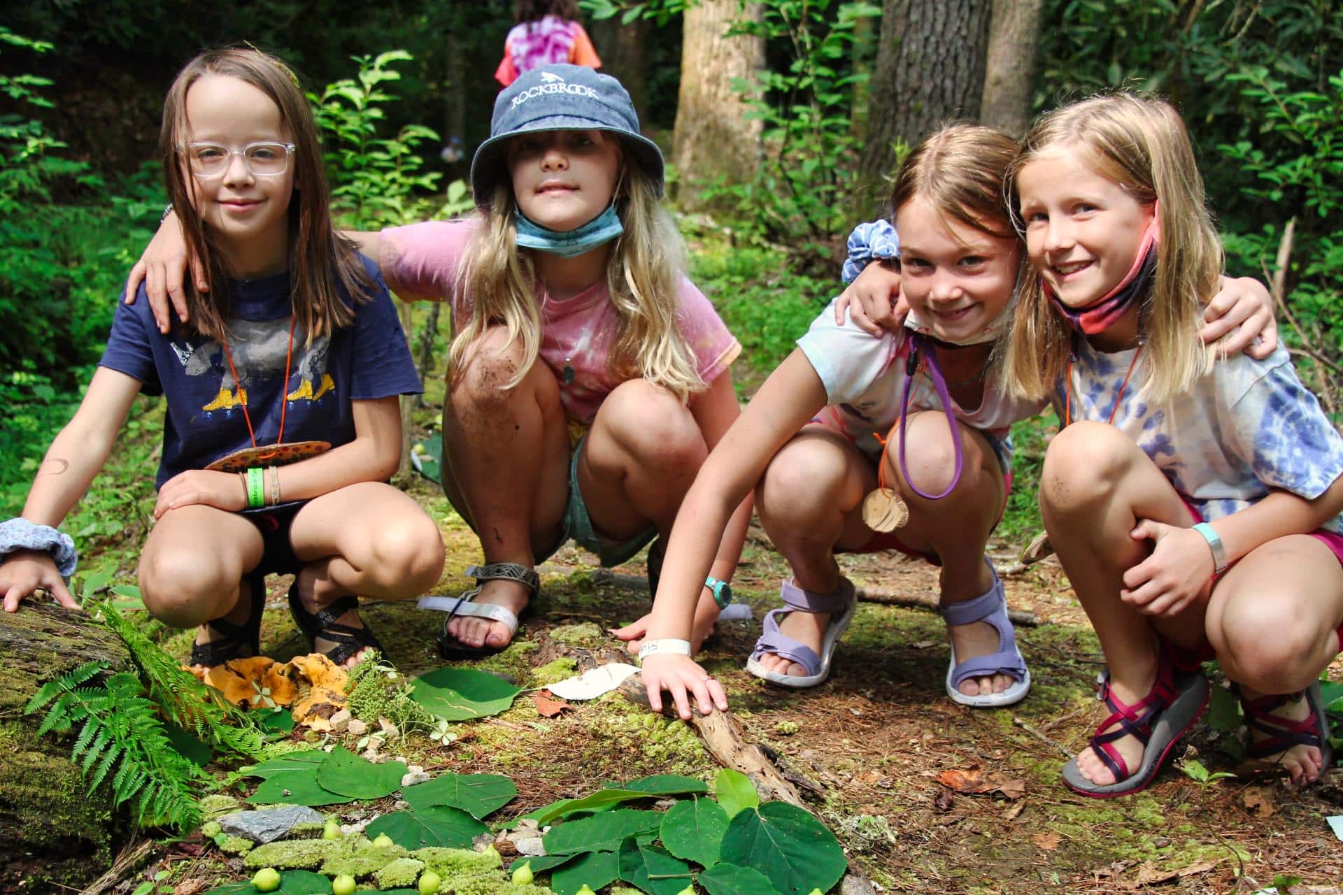 small camp girls building fairy houses