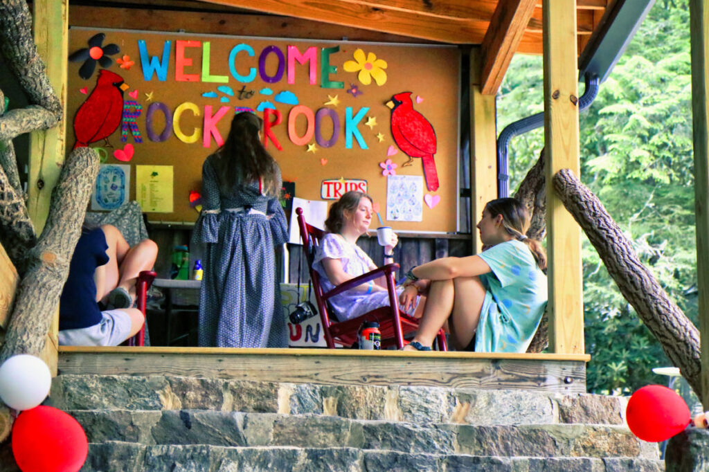 girls relaxing on porch at camp