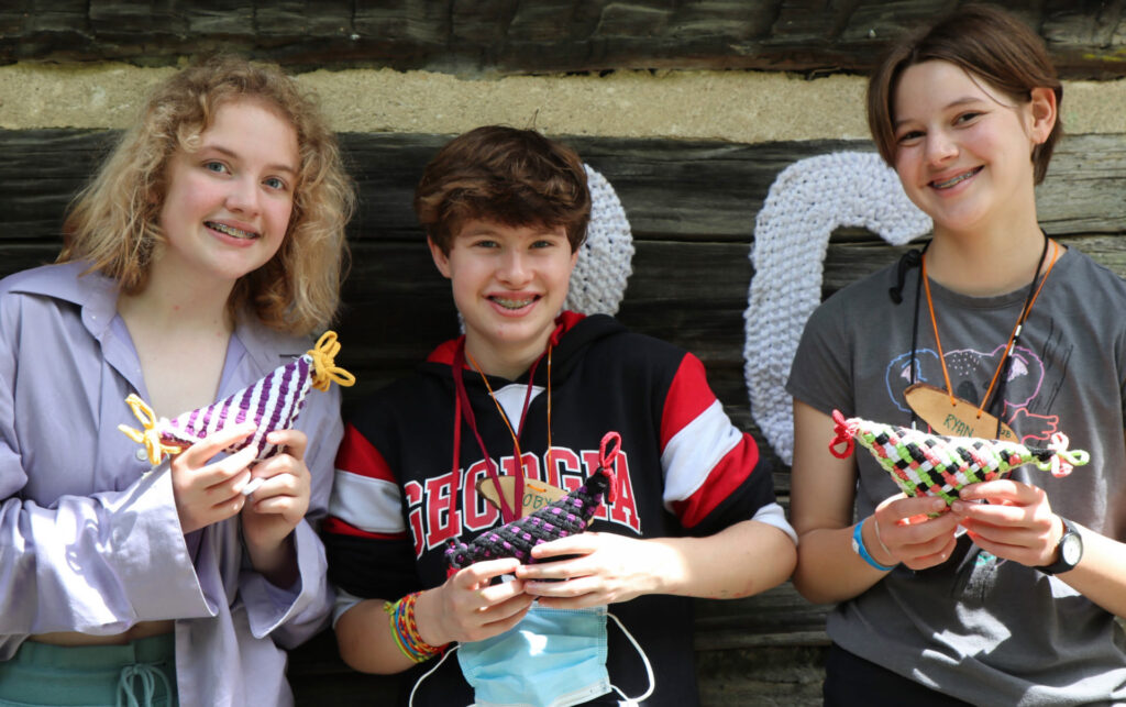 kids holding woven chickens