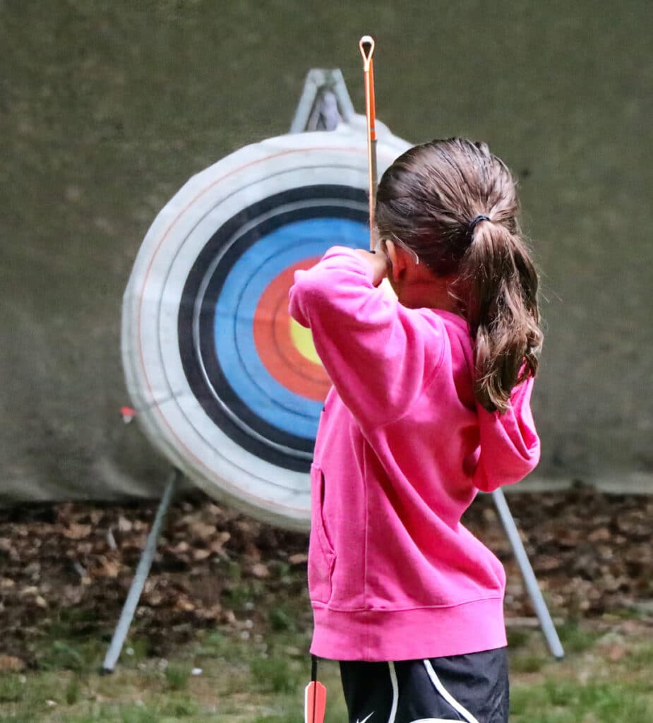 summer camp girl aiming archery