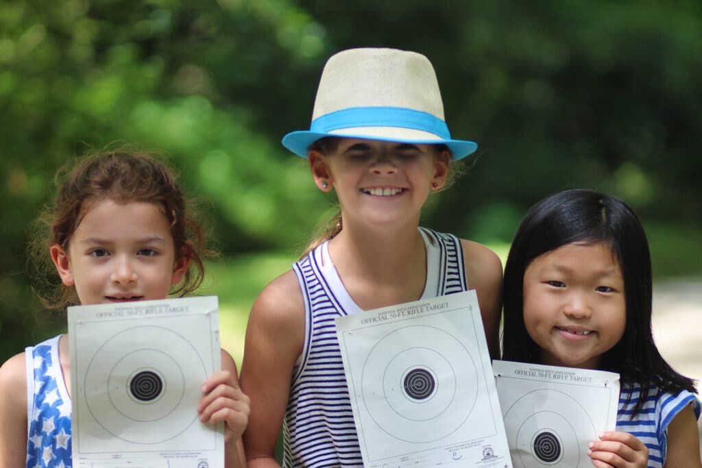 summer camp kids holding targets