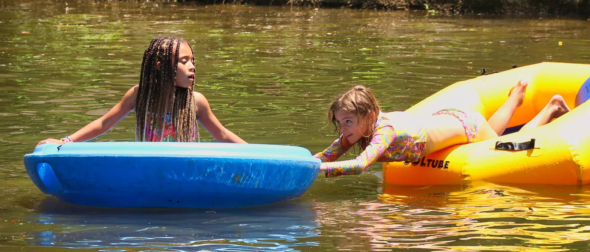 girls playing at summer camp lake