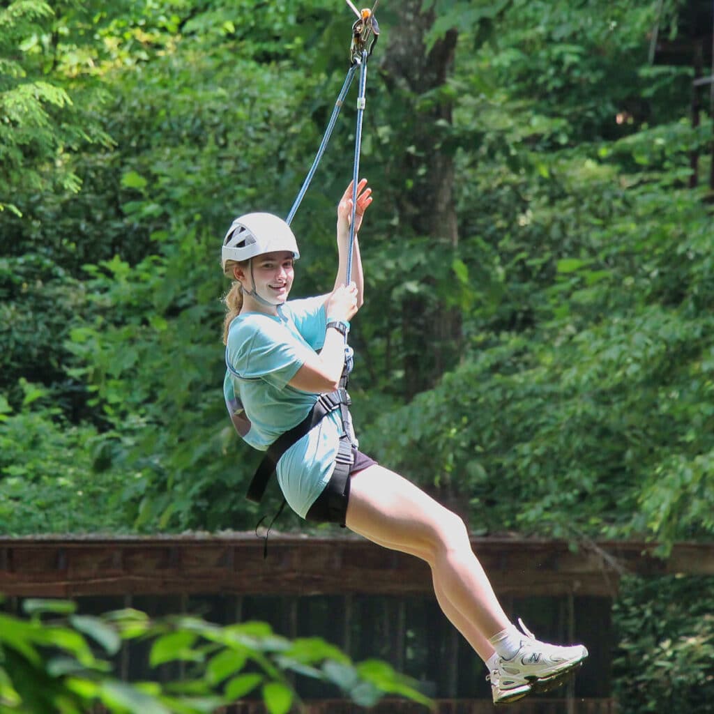 summer camp camper on zip line