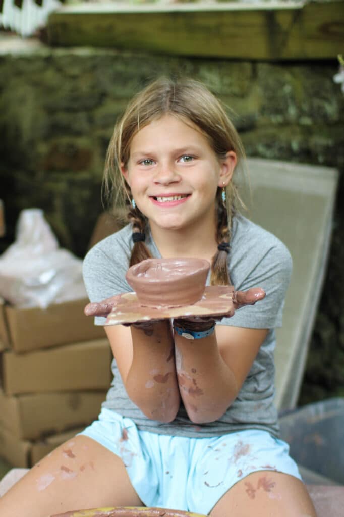 girl holding camp pottery project