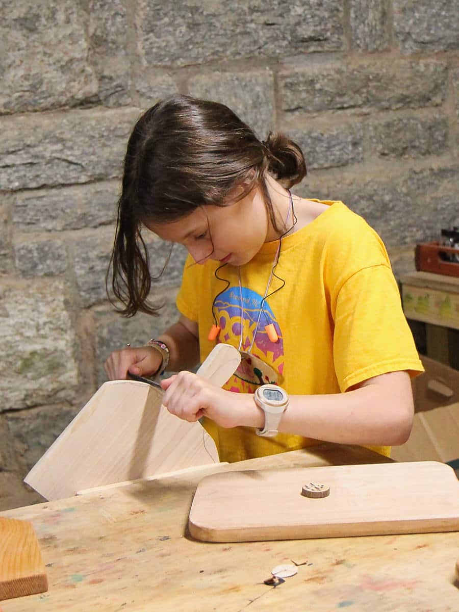 summer camp kid doing woodworking