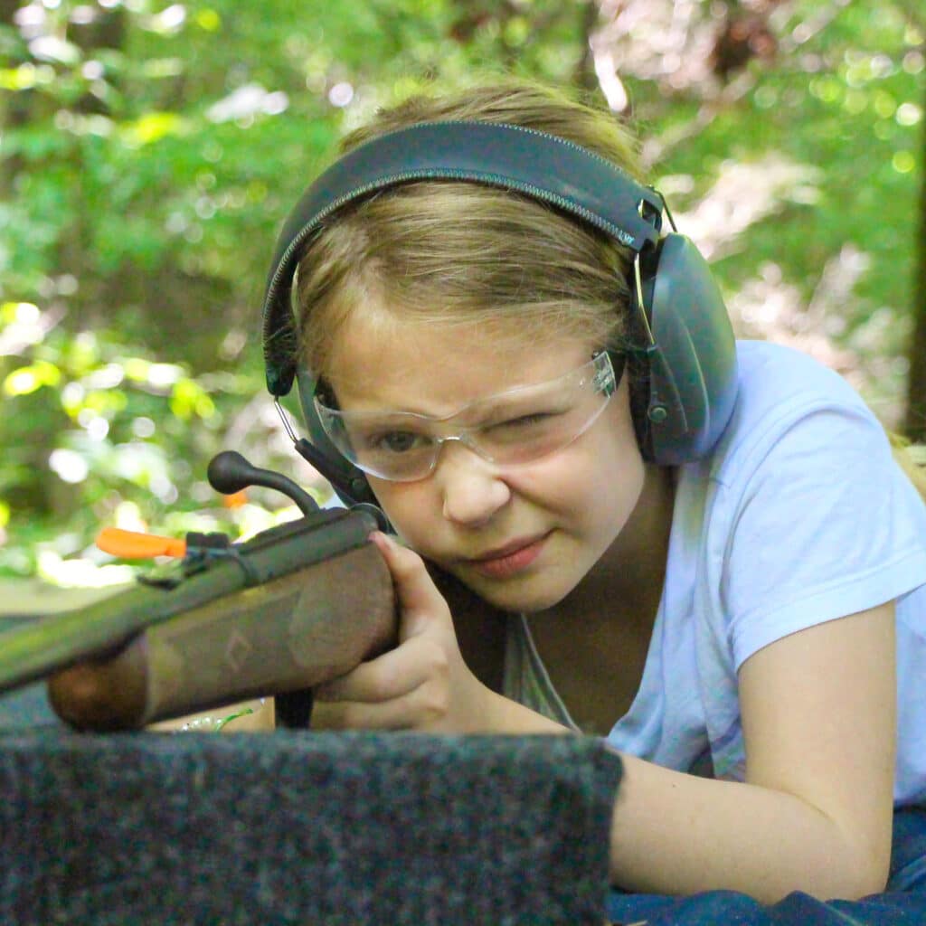 summer camp girl aiming rifle