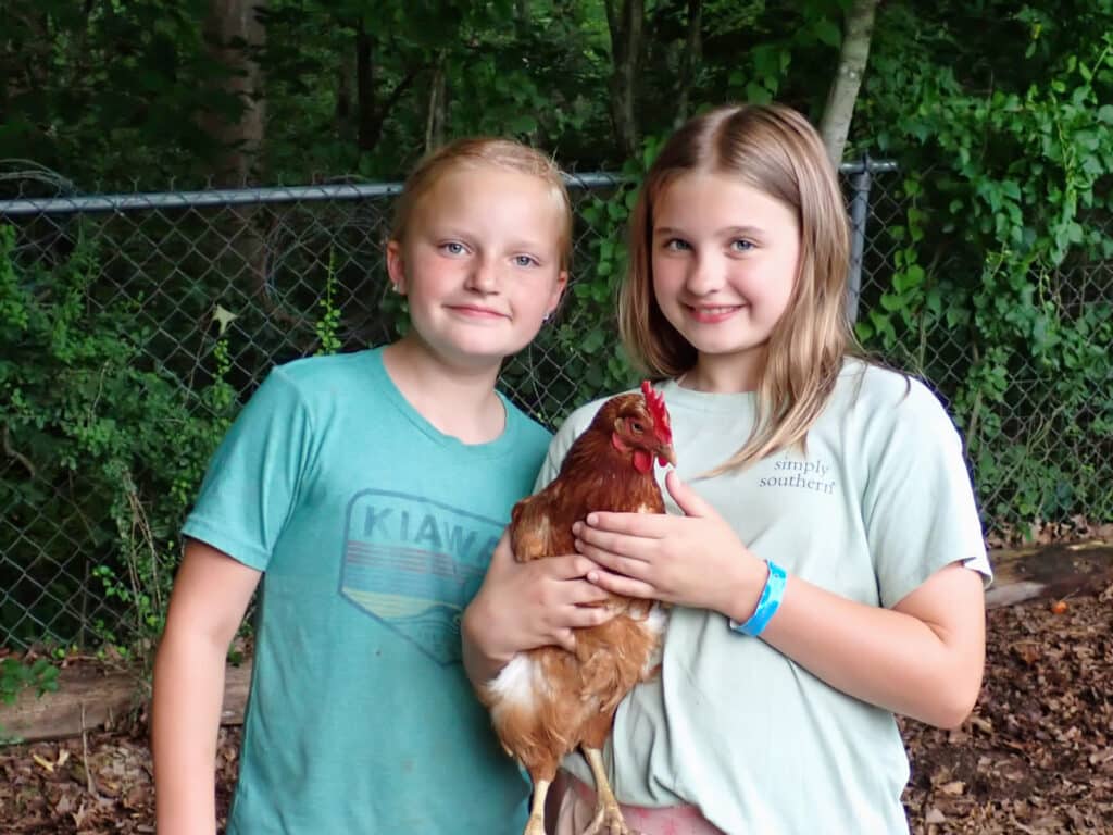 summer camp girls holding a chicken