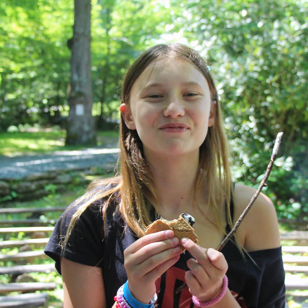 camp girl eating s'more