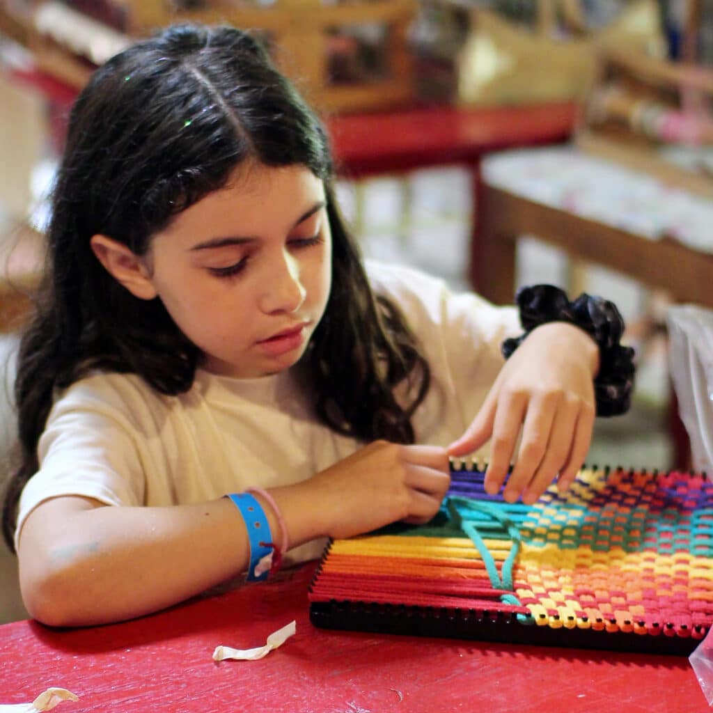 child weaving by hand