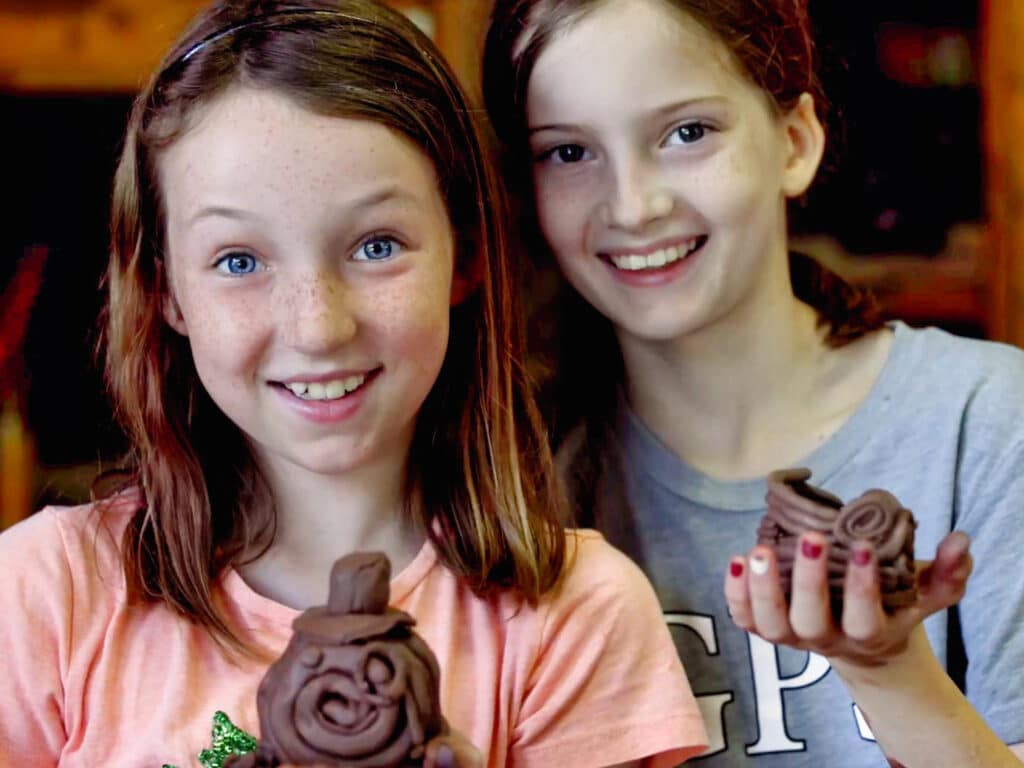 girls displaying their pottery projects