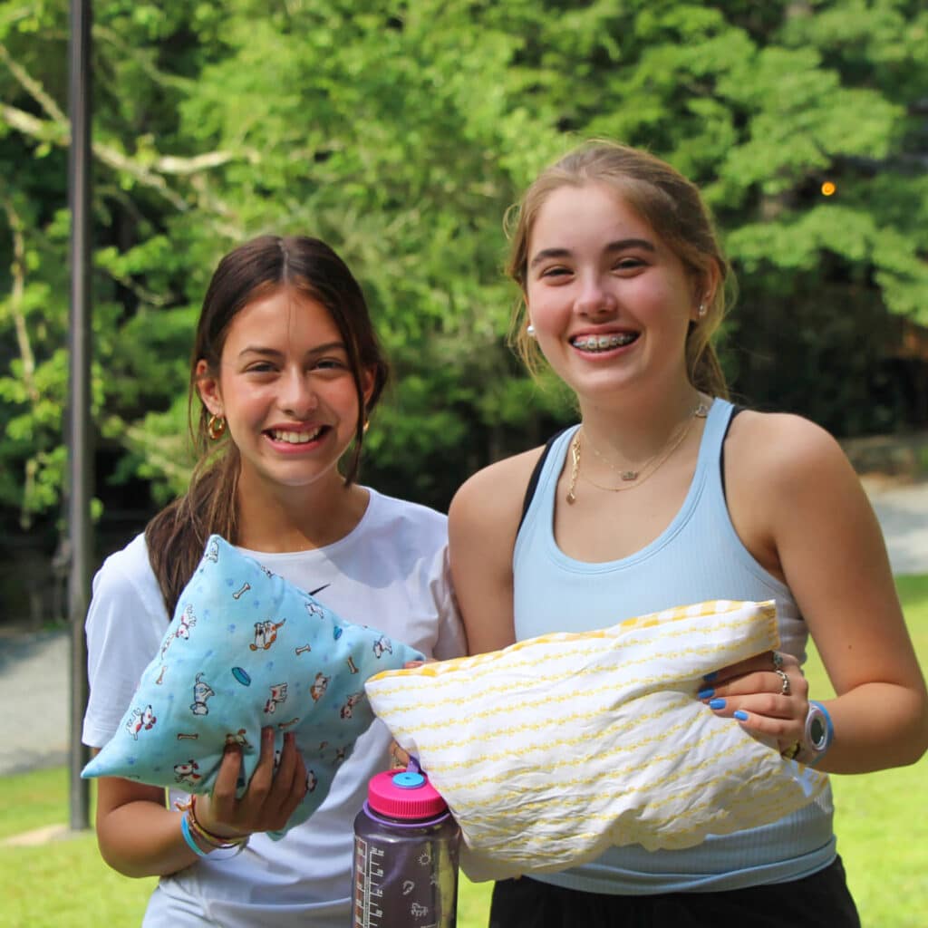 teen girls holding sewing pillows