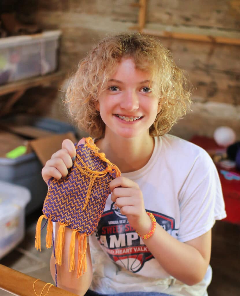 camp kid showing her weaving